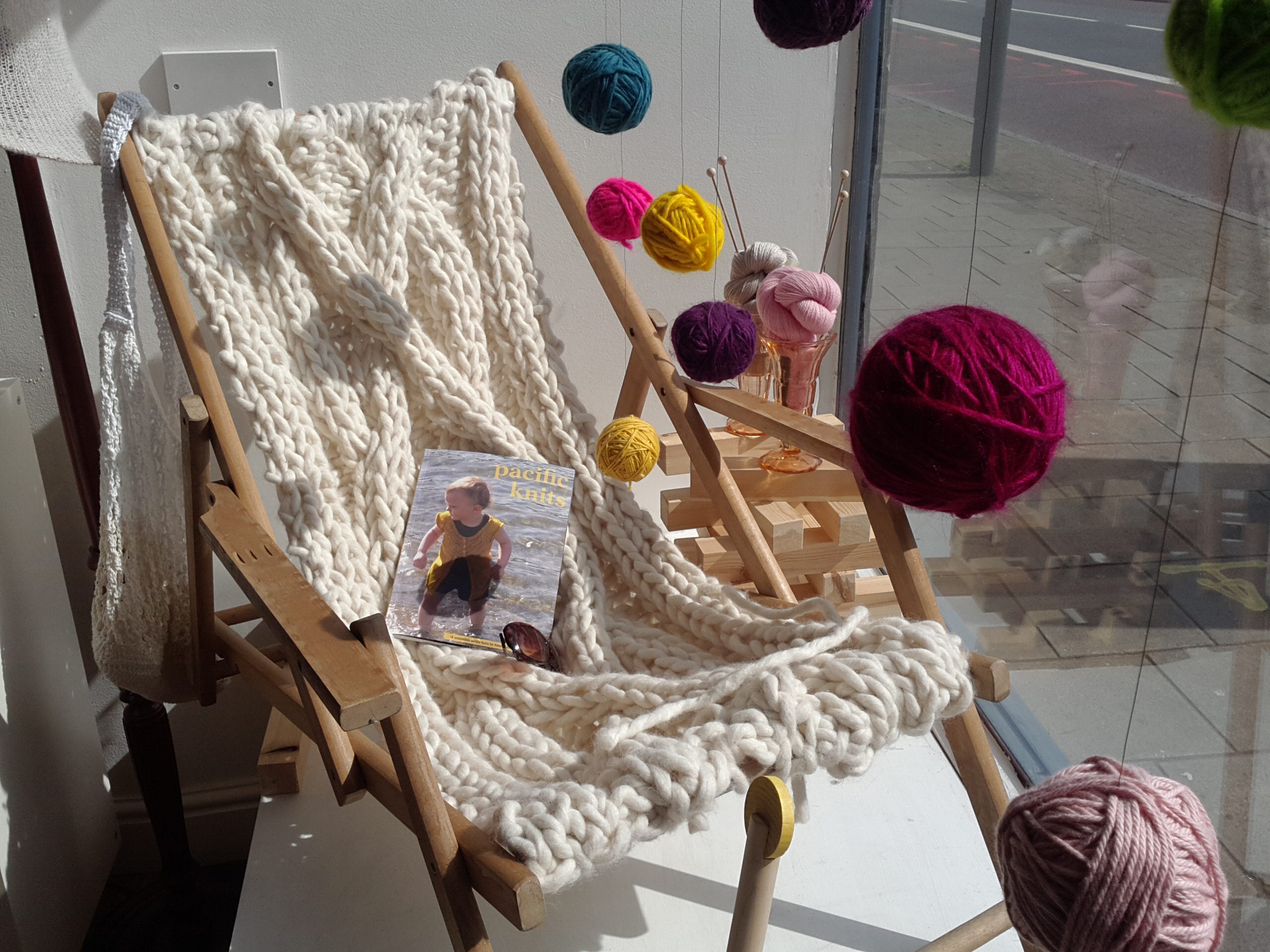 June window display with knitted deckchair, woolly sundaes and ball garlands